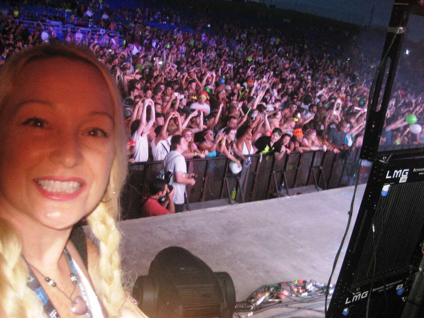 A person taking a selfie in front of a large crowd Description automatically generated