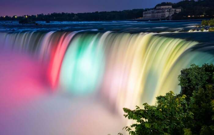 Most Beautiful Waterfalls in the World that Will Take Your Breath Away A large waterfall with a building in the background Description automatically generated with low confidence