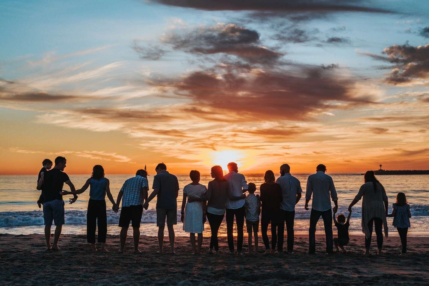 A group of people standing on a beach Description automatically generated with medium confidence