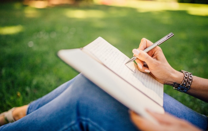 5 Hobbies Every Travel-Lover Should Have A person writing in a notebook Description automatically generated